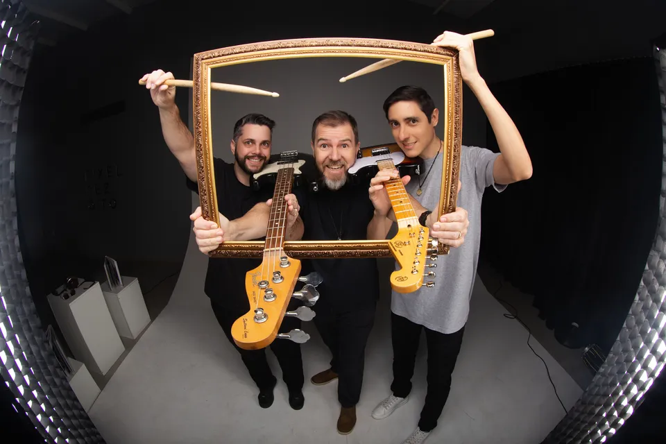 Registro do acervo da banda: músicos brincam com uma moldura e instrumentos